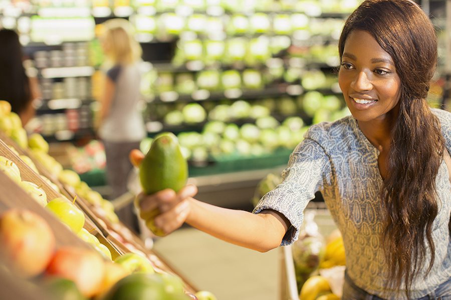 Grocery Store Insurance - Young Woman Shopping for Produce in a Grocery Store