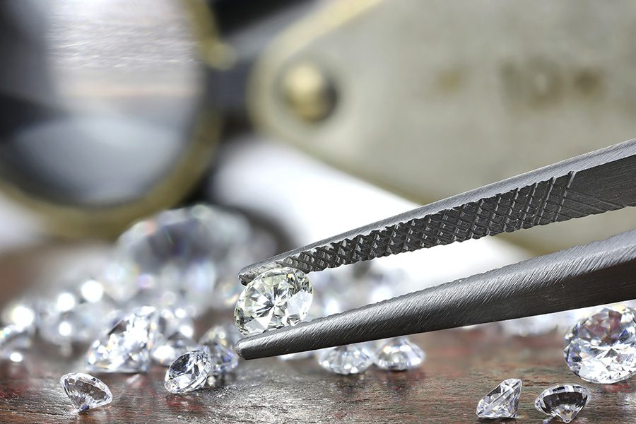 Jewelers Insurance - Closeup View of Brilliant Cut Diamond Held by Jeweler Using Tweezers